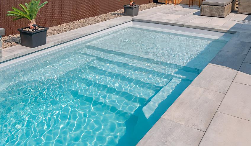 A modern backyard featuring a sleek fiberglass pool with a smooth surface and crystal-clear water