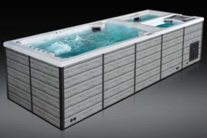Rectangular hot tub with wood-look panels, blue water, and multiple jets visible inside.