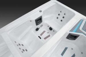White hot tub interior with multiple jet nozzles and built-in seating areas inside a glossy acrylic tub.
