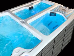 A multi-seat hot tub with bright blue water and built-in jets, mounted on a wooden deck surface.