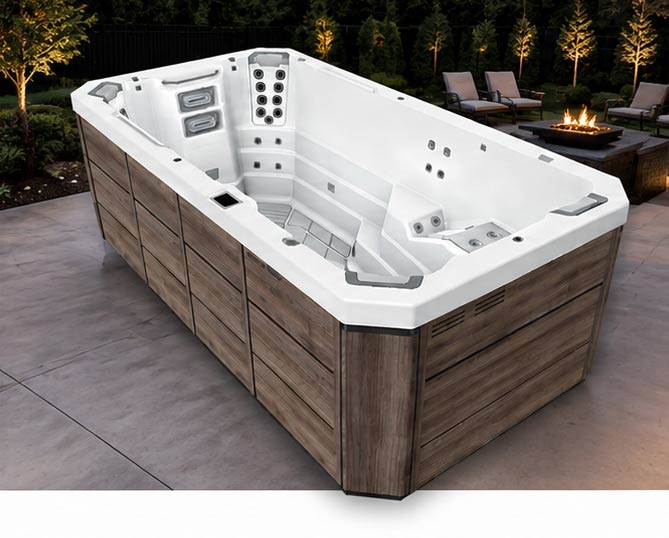 Outdoor white hot tub with multiple seats and built-in jets, surrounded by wood panels on a patio with a fire pit in the background.